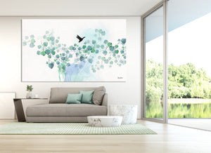 Large watercolor art of turquoise leaves, above a gray sofa