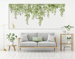 Watercolor painting of green leaves, hanged above a gray sofa